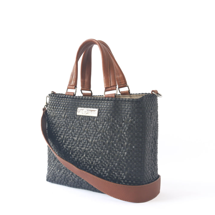Side angle All black woven crossbody drawstring bag with tan leather— handmade from recycled plastic, Tin Marin