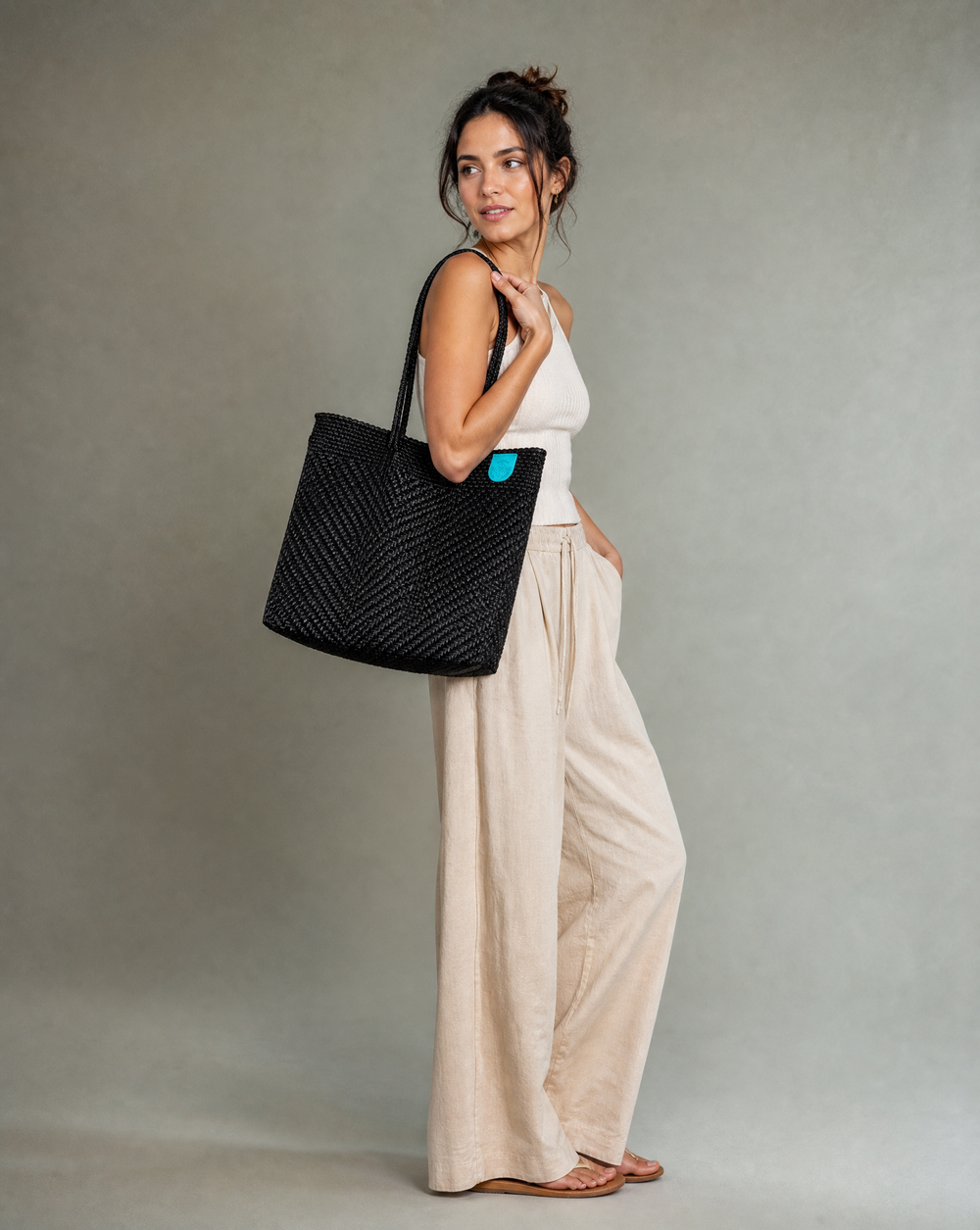 Woman carrying all black Woven Tote