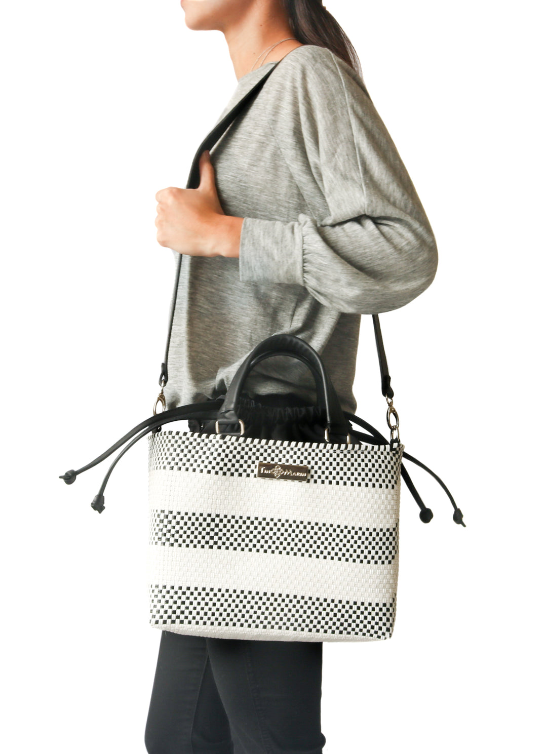 Woman wearing Lolo medium woven crossbody bag on shoulder — Tin Marin