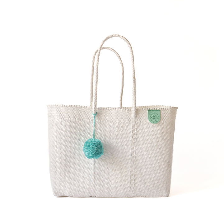 Tin Marin super tote in Paloma Design, A white oversized tote bag with a pompom decoration, and a shoulder strap.
