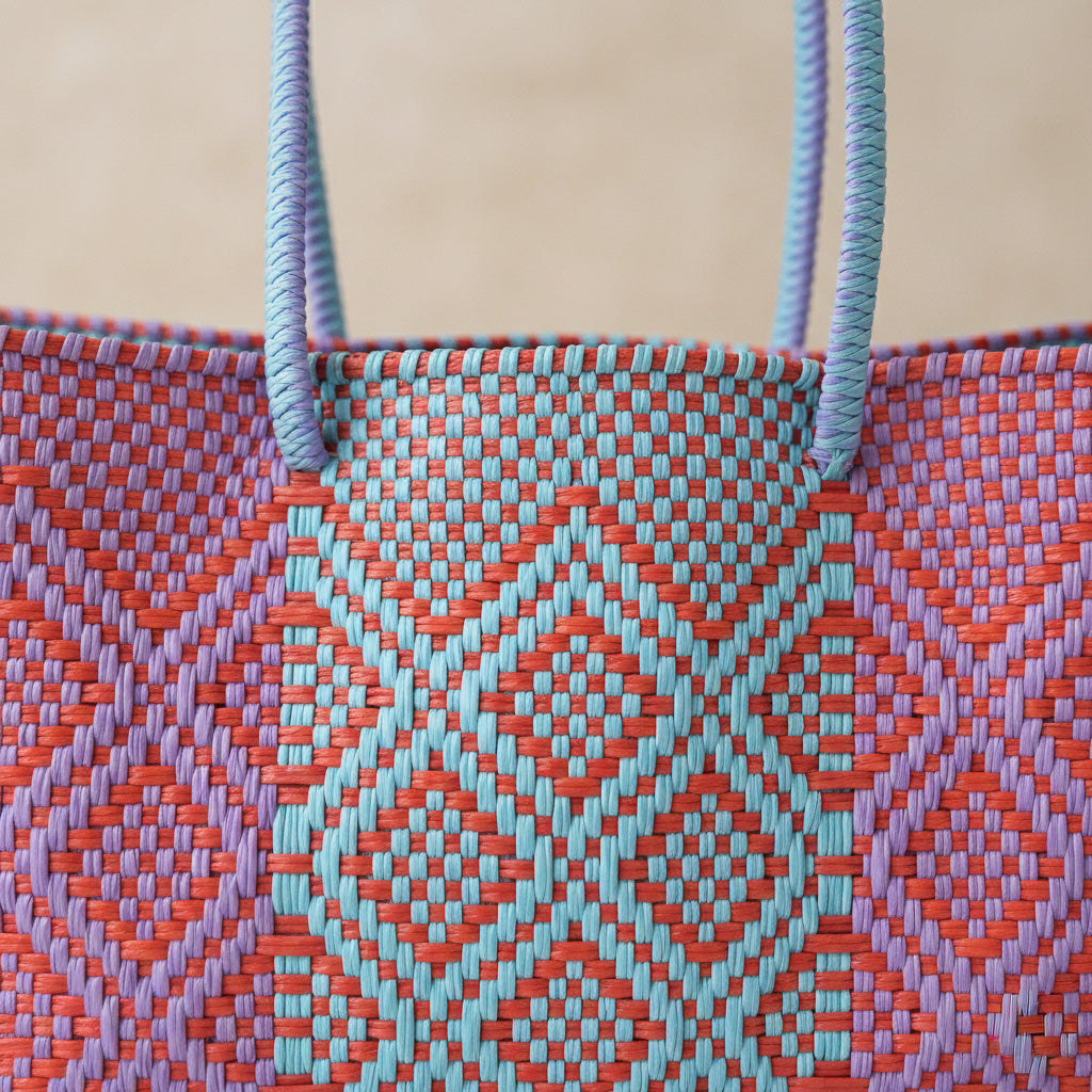 Close up of Tin Marin super tote in Sunset Design, A purple, blue and orange oversized tote bag with a shoulder strap.