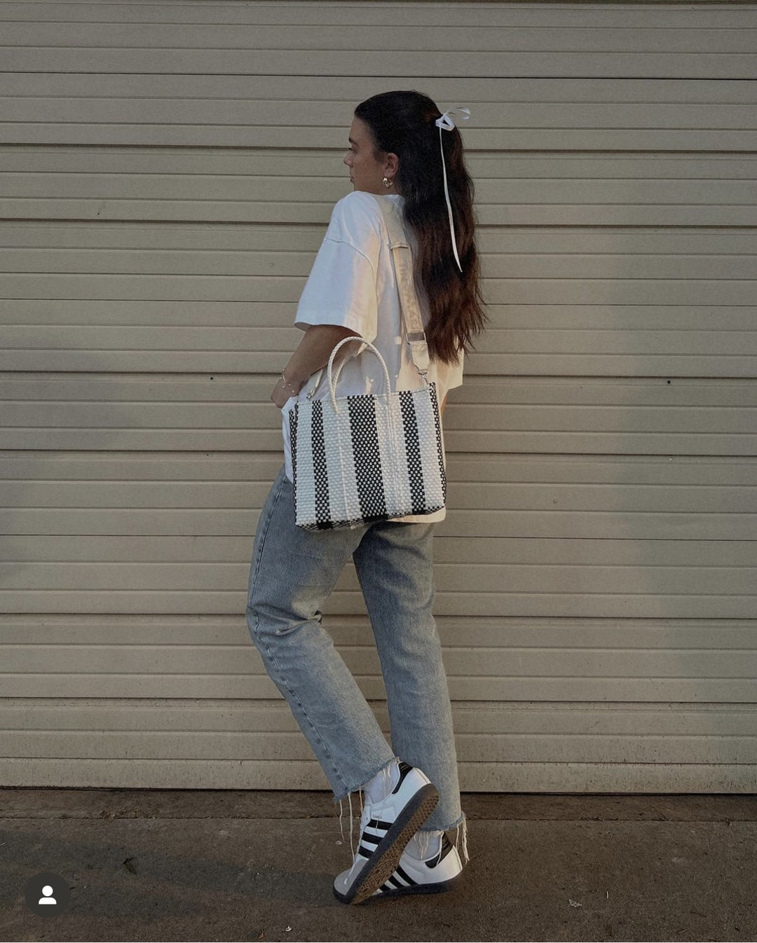Woman wearing Zebra medium woven crossbody bag — Tin Marin Resort Collection