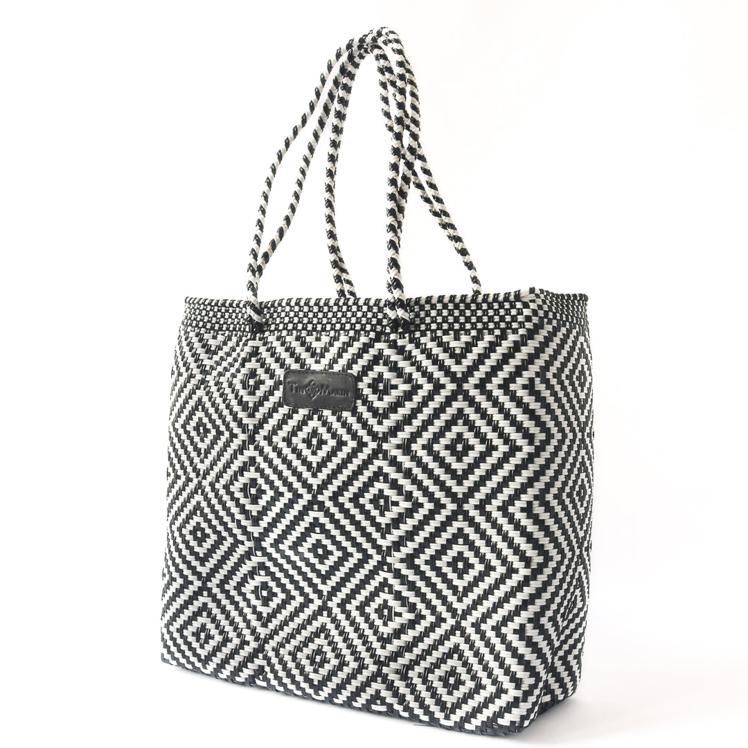Side angle Greca woven tote in black and white— handmade from recycled plastic in Mexico by Tin Marin
