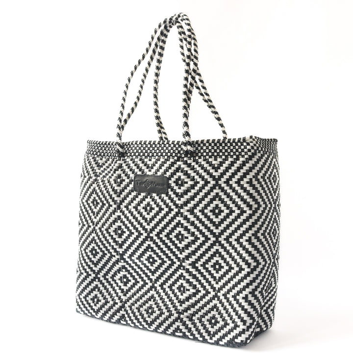 Side angle Greca woven tote in black and white— handmade from recycled plastic in Mexico by Tin Marin
