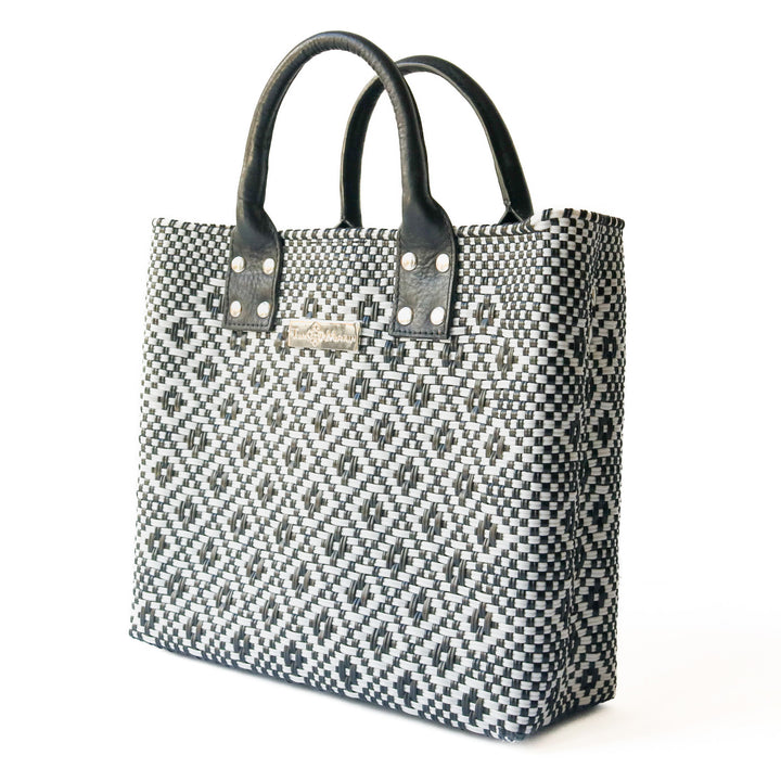 Side angle Panda large woven crossbody bag in white and black with black leather— handmade from recycled plastic in Mexico by Tin Marin