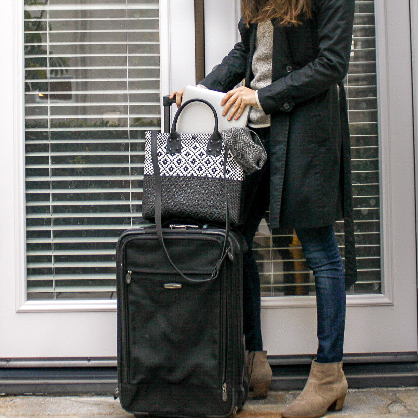 Woman wearing Tin Marin Black large woven crossbody bag in white and black— handmade from recycled plastic in Mexico by Tin Marin