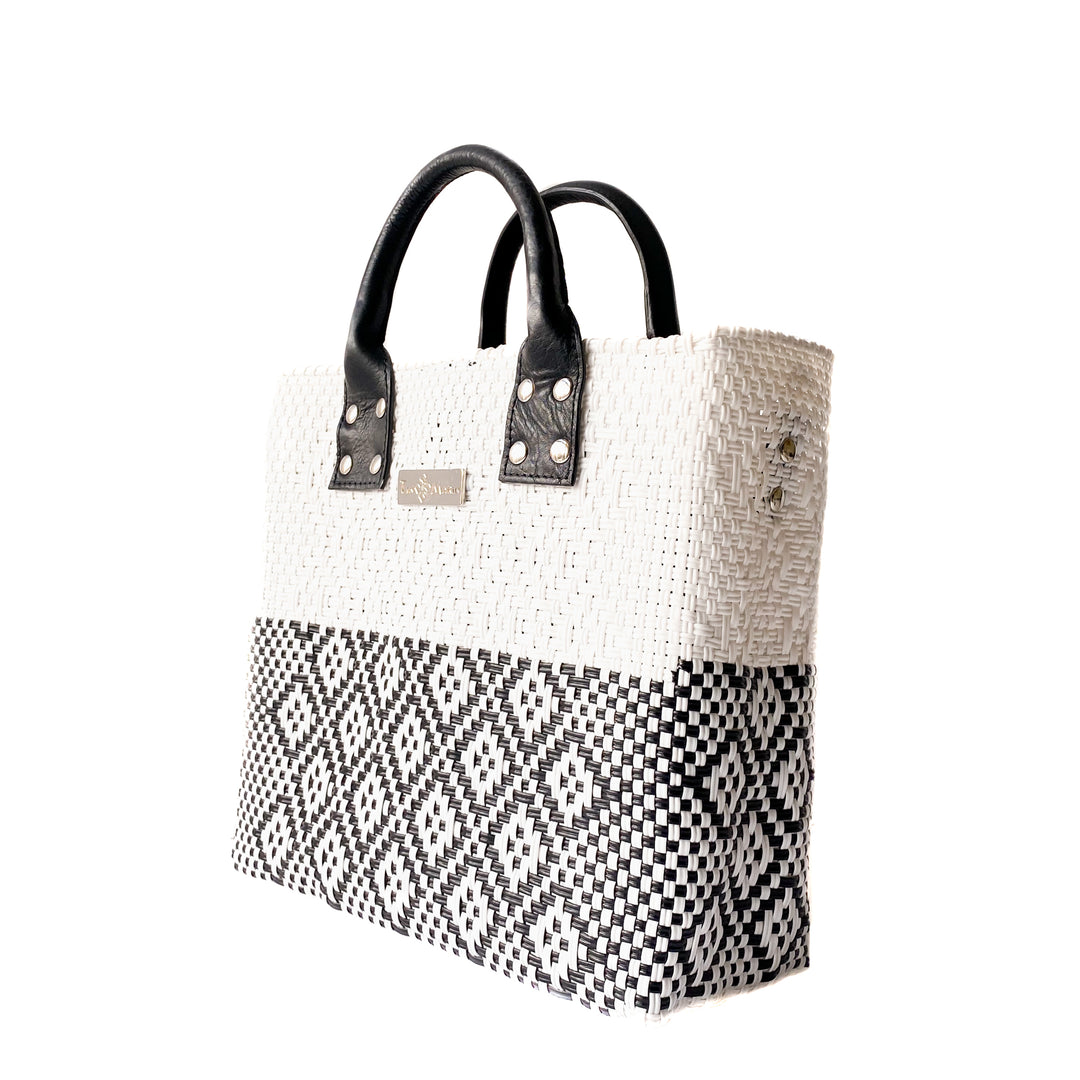 Side angle Tin Marin White Large woven crossbody bag in white and black with black leather — handmade from recycled plastic in Mexico by Tin Marin