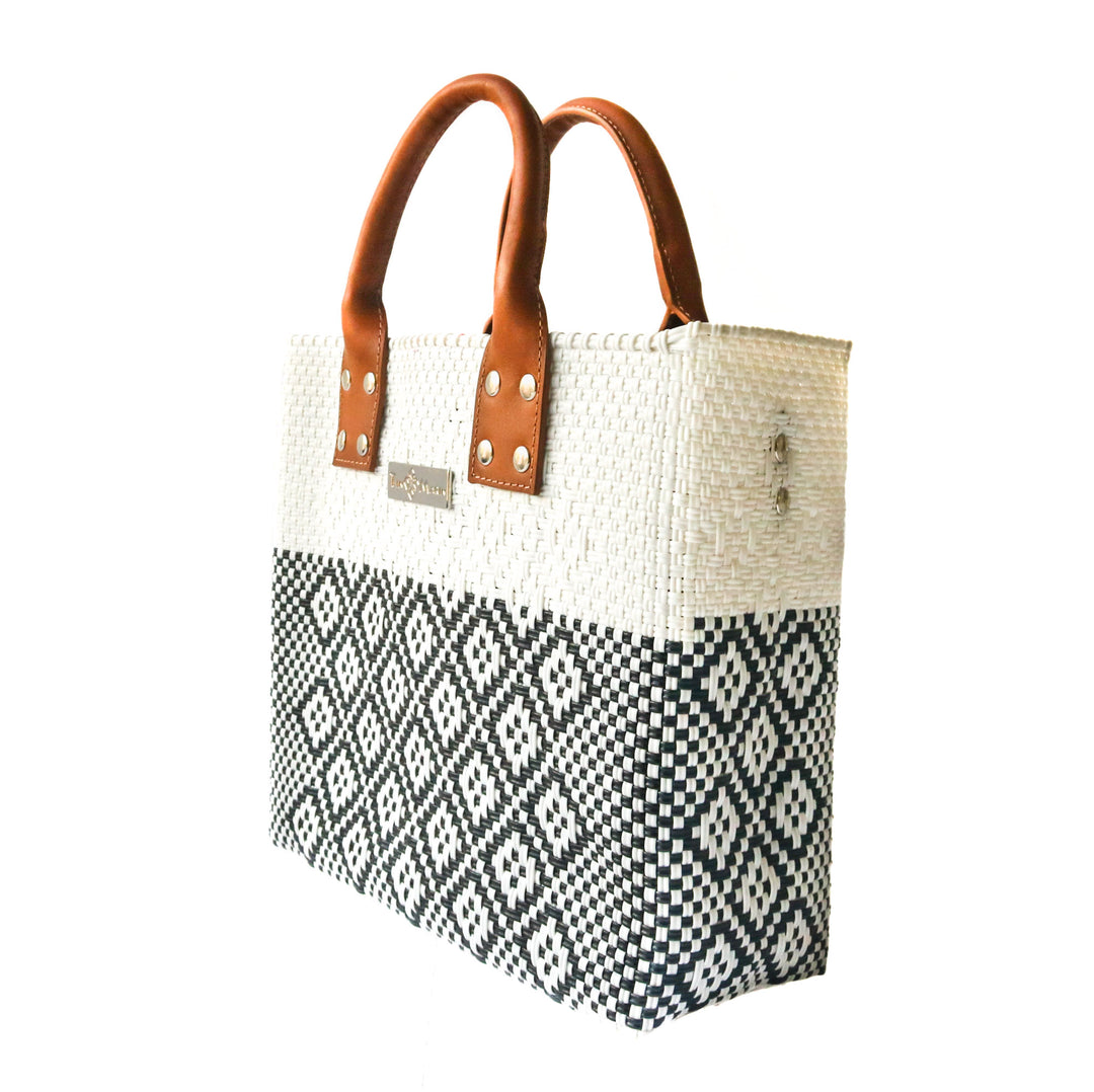 Side angle Tin Marin White Large woven crossbody bag in white and black with tan leather— handmade from recycled plastic in Mexico by Tin Marin