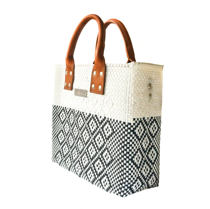 Side angle Tin Marin White Large woven crossbody bag in white and black with tan leather— handmade from recycled plastic in Mexico by Tin Marin