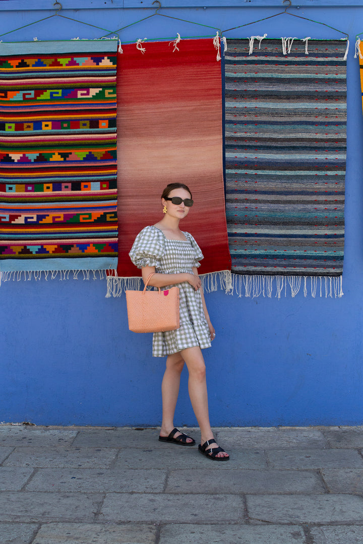 Woman wearing Canarias medium woven crossbody bag — Tin Marin Resort Collection